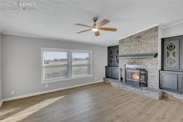 unfurnished living room with lofted ceiling, ceiling fan, light wood-type flooring, a textured ceiling, and a fireplace