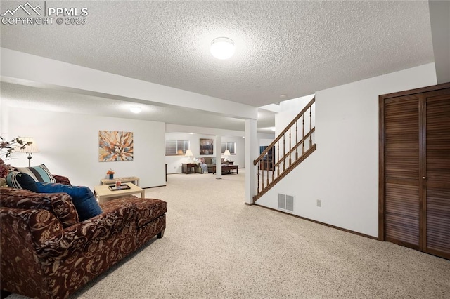 carpeted living room featuring a textured ceiling