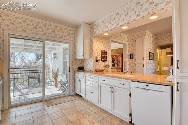 kitchen featuring dishwasher, sink, light tile patterned floors, crown molding, and white cabinets