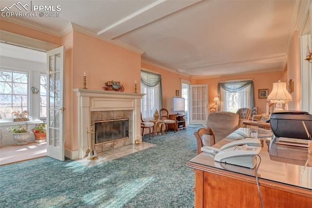 living room featuring a tiled fireplace, french doors, carpet, and ornamental molding