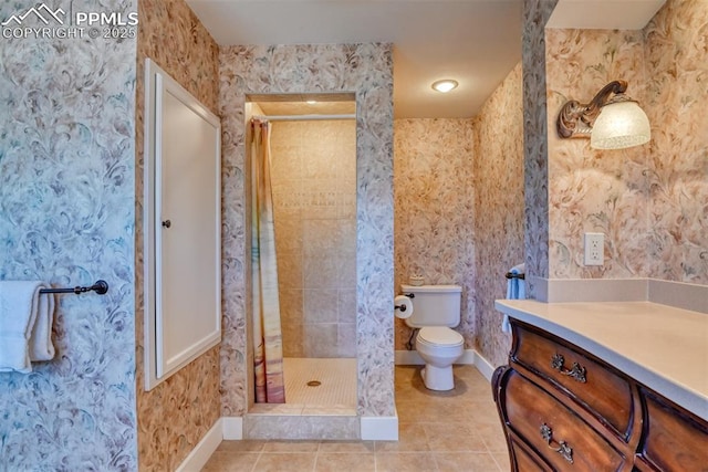 bathroom featuring tiled shower, vanity, tile patterned flooring, and toilet