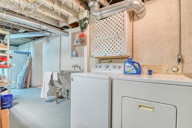 clothes washing area with washing machine and dryer and sink