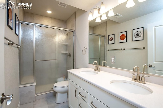 bathroom featuring tile patterned floors, vanity, an enclosed shower, and toilet