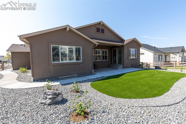 back of property with a lawn and a patio area