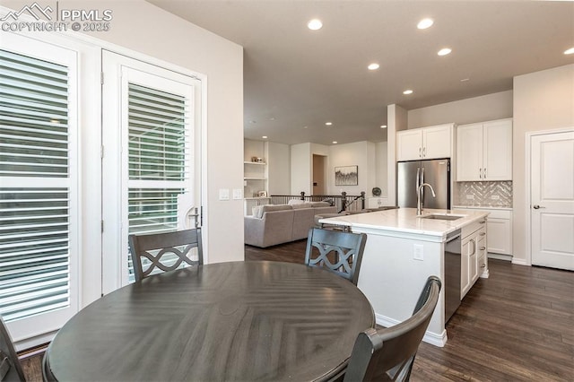 dining area featuring sink and dark wood-type flooring