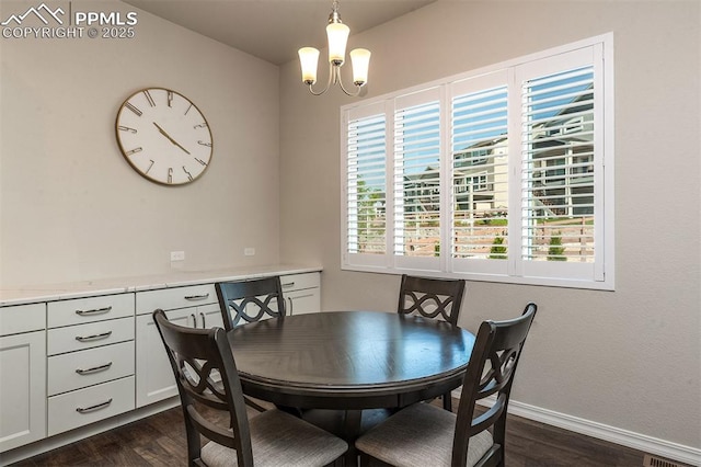 dining space with dark hardwood / wood-style floors and an inviting chandelier