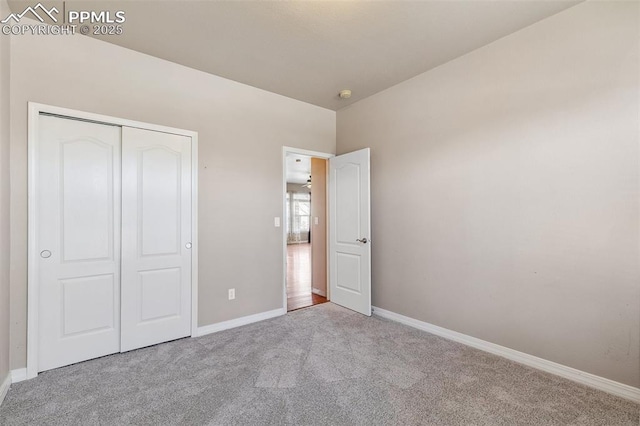 unfurnished bedroom featuring light carpet and a closet