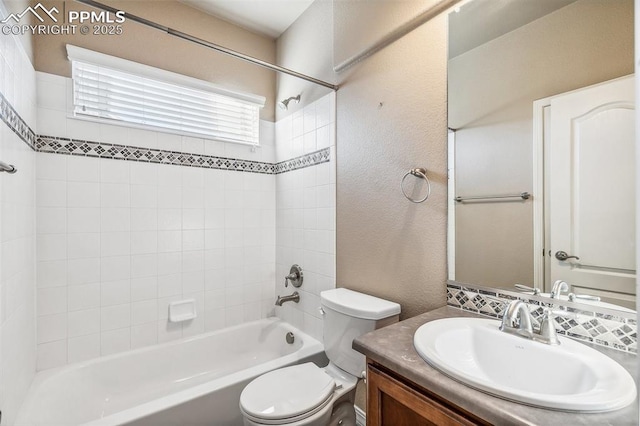 full bathroom with toilet, vanity, and tiled shower / bath