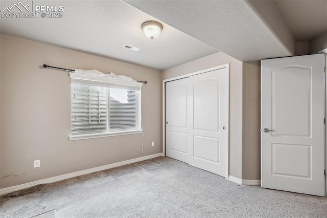 unfurnished bedroom with light carpet and a closet