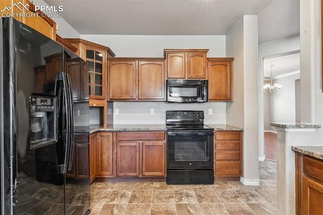 kitchen with black appliances, a notable chandelier, light stone countertops, and crown molding