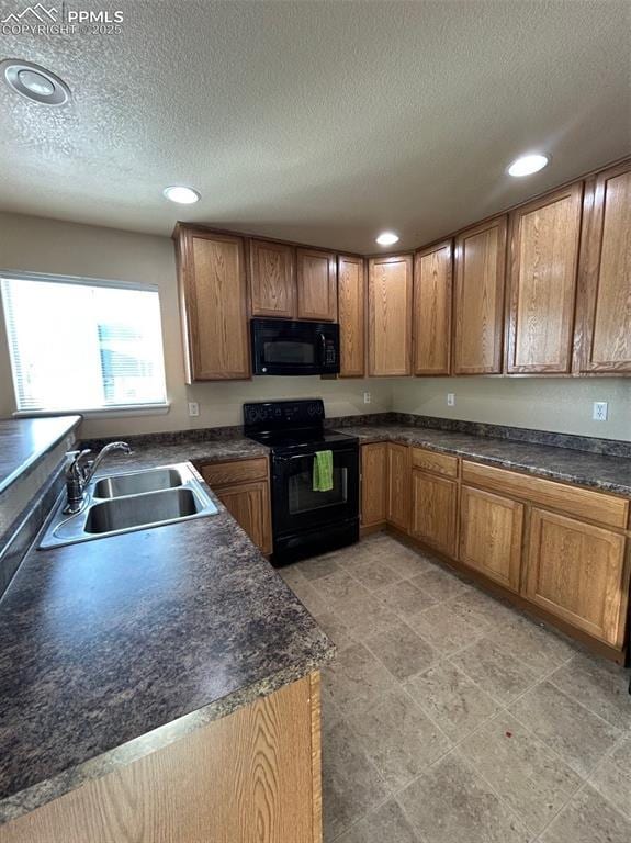 kitchen with sink, black appliances, and a textured ceiling