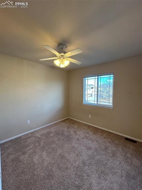 carpeted spare room featuring ceiling fan