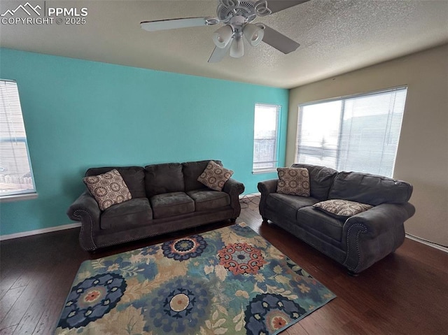 living room with a textured ceiling, dark hardwood / wood-style flooring, and ceiling fan