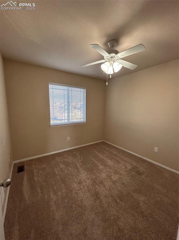 carpeted spare room with ceiling fan