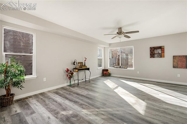 empty room with hardwood / wood-style floors and ceiling fan