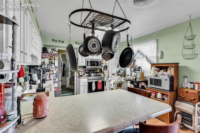 kitchen featuring stainless steel appliances, white cabinetry, and sink