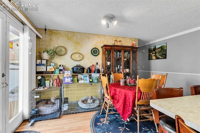 dining room with wood-type flooring and a textured ceiling