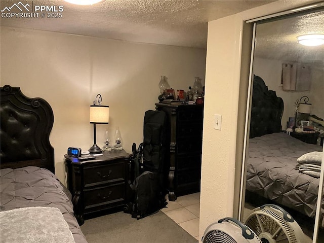 bedroom featuring a textured ceiling and light tile patterned floors