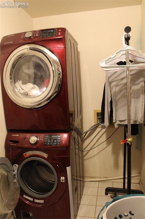 laundry room featuring stacked washer / dryer and light tile patterned floors