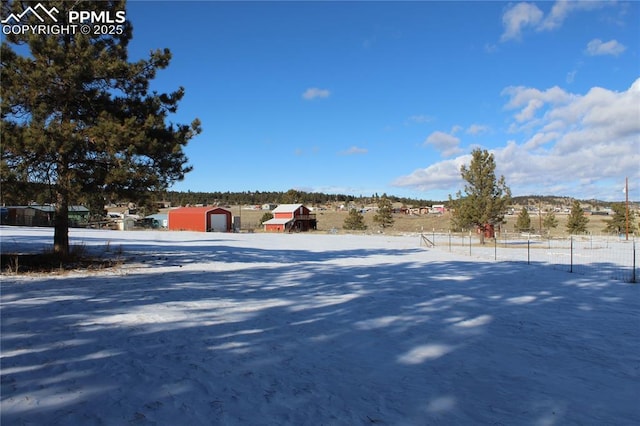 snowy yard featuring an outbuilding