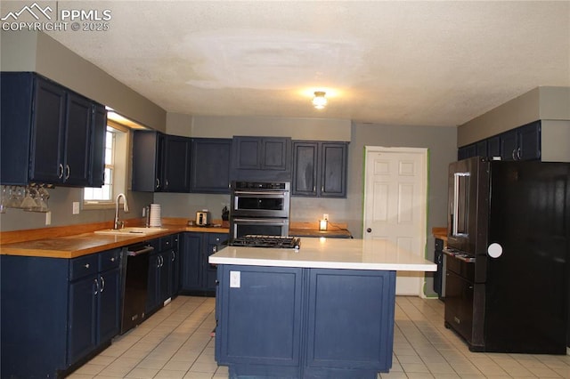 kitchen with blue cabinetry, sink, a center island, and black appliances