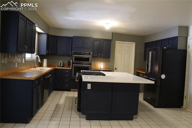 kitchen with wooden counters, black appliances, sink, light tile patterned floors, and a kitchen island