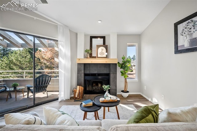 living room featuring hardwood / wood-style floors and a tile fireplace