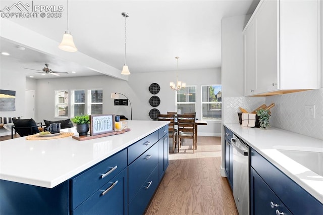 kitchen featuring white cabinets, a center island, stainless steel dishwasher, and blue cabinets