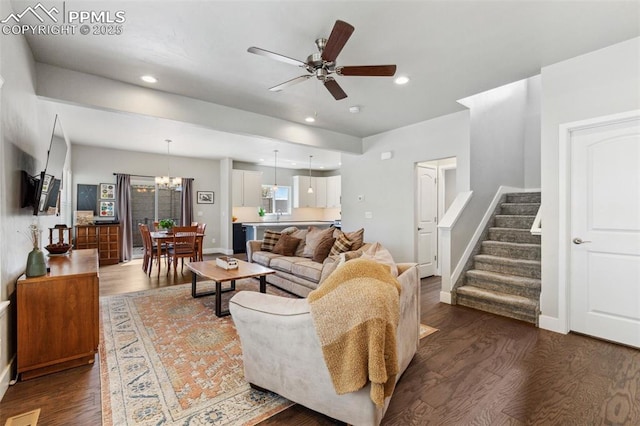 living room featuring ceiling fan with notable chandelier and dark hardwood / wood-style flooring