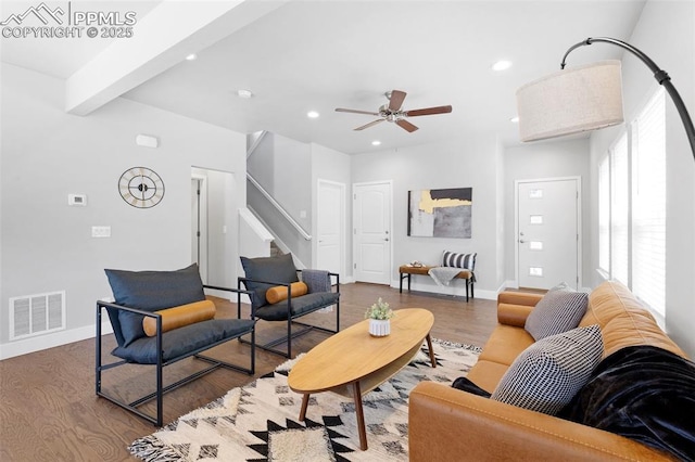 living room with hardwood / wood-style floors, ceiling fan, and beam ceiling