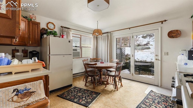 kitchen with range, white fridge, baseboard heating, and light colored carpet