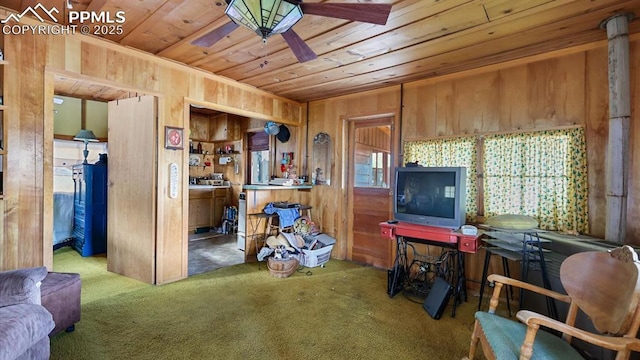 interior space featuring ceiling fan, wooden walls, and wood ceiling