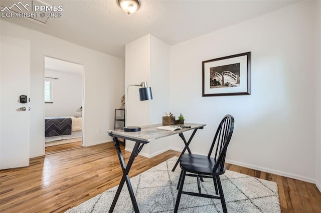 office with hardwood / wood-style floors and a textured ceiling