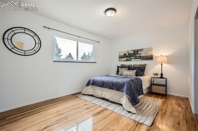 bedroom with hardwood / wood-style floors and a textured ceiling