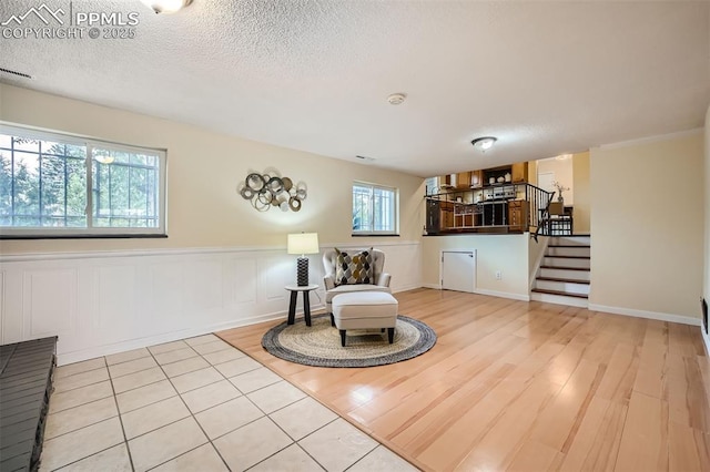 sitting room featuring a textured ceiling, light hardwood / wood-style floors, and a wealth of natural light