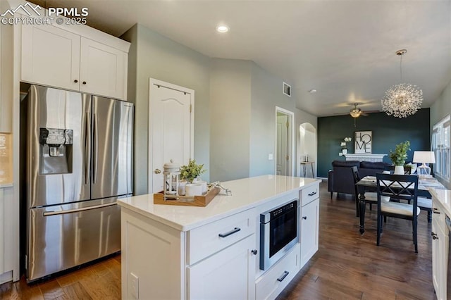 kitchen featuring hanging light fixtures, built in microwave, stainless steel fridge with ice dispenser, white cabinets, and dark hardwood / wood-style flooring