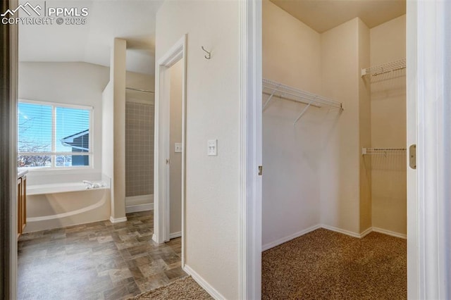 interior space with vaulted ceiling and a bathtub