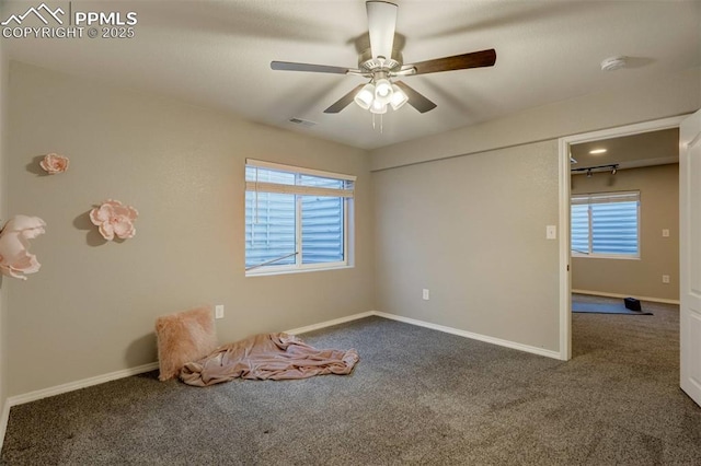 unfurnished bedroom featuring ceiling fan, multiple windows, and carpet floors