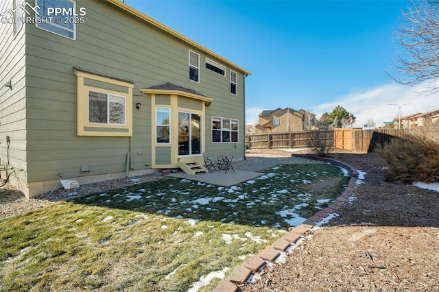 rear view of house featuring a lawn and a patio