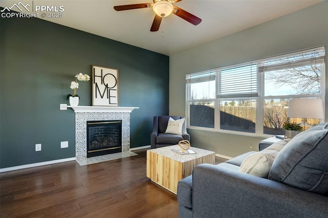 living room with ceiling fan, dark hardwood / wood-style floors, and a fireplace