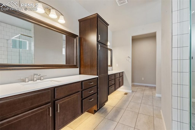 bathroom featuring tile patterned flooring, vanity, and a shower with door