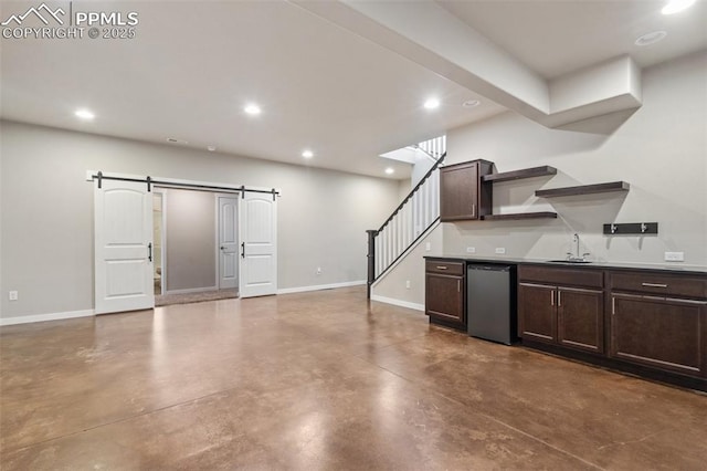 kitchen with stainless steel dishwasher, dark brown cabinets, a barn door, and sink