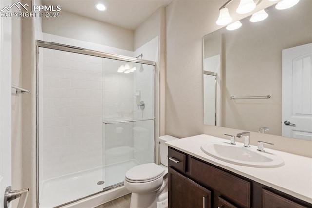 bathroom featuring an enclosed shower, vanity, and toilet