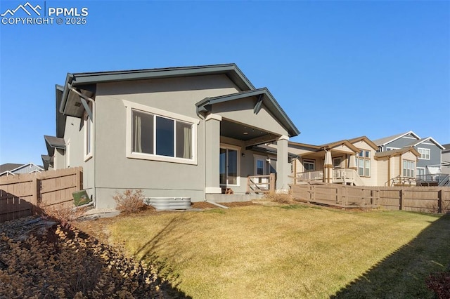 rear view of house featuring a yard