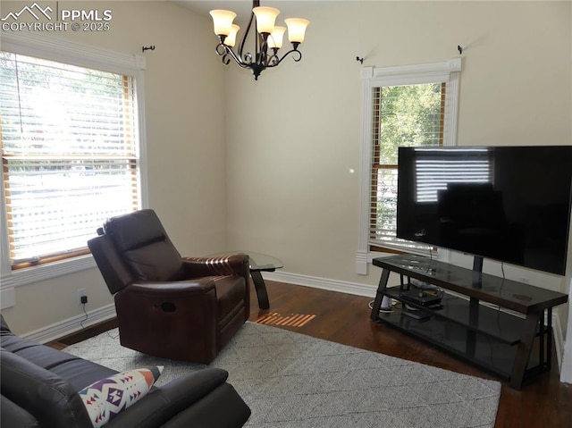 living room featuring wood-type flooring and an inviting chandelier