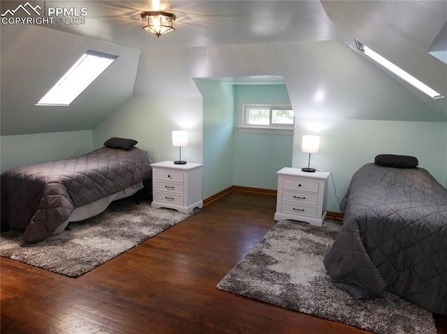 bedroom featuring dark wood-type flooring and vaulted ceiling with skylight