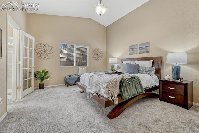 bedroom with ensuite bathroom, lofted ceiling, and light carpet