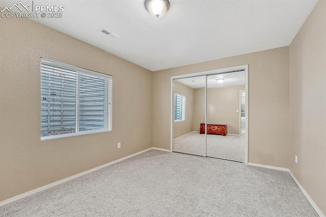 unfurnished bedroom with carpet floors and a closet