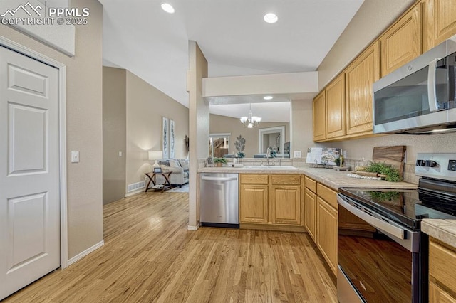 kitchen with light brown cabinets, sink, appliances with stainless steel finishes, light hardwood / wood-style floors, and a chandelier