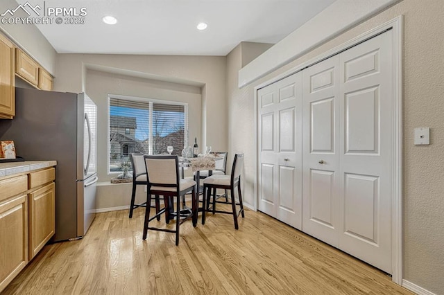 dining room with lofted ceiling and light hardwood / wood-style flooring